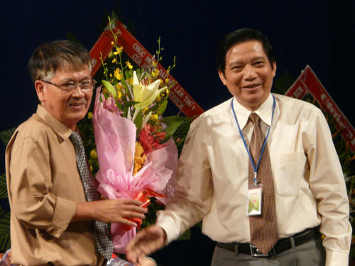 Ông Lê Văn Thảo, Chủ tịch Hội Nhà văn TPHCM khóa V, chúc mừng tân Chủ tịch Hội Nhà văn TPHCM Lê Quang Trang (phải)