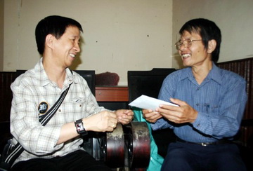 Nhà thơ Lâm Xuân Thi (trái) trao tiền giúp nhà thơ Hà Nguyên Dũng