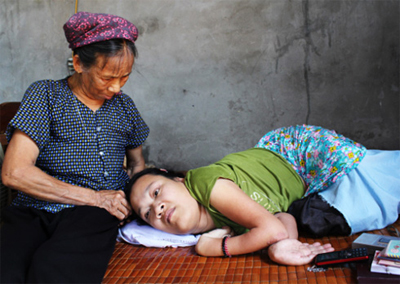 Thương con đến thắt ruột, nhưng người mẹ già Trần Thị Mấn cũng chẳng thể giúp con chữa bệnh. Ảnh: Chu Hiền.