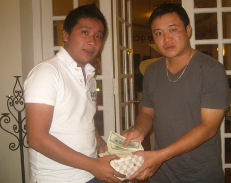 Trung úy Hải (bên phải) bàn giao lại tài sản nhặt được cho người thân của chị Ninh. Ảnh: Quỳnh Chi